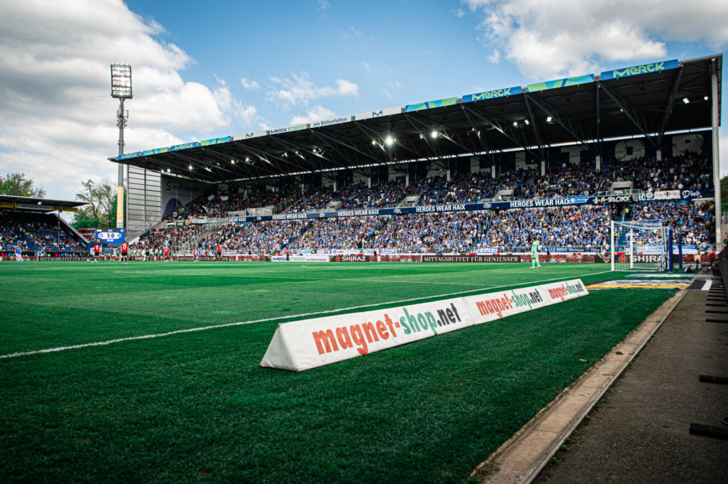 Das ausverkaufte Merck-Stadion am Böllenfalltor bei leicht bewölktem Himmel.
