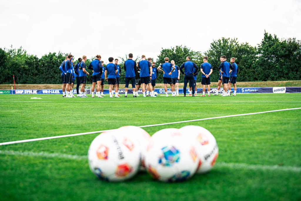 Die Spieler des SV 98 stehen im Kreis auf dem Trainingsplatz.