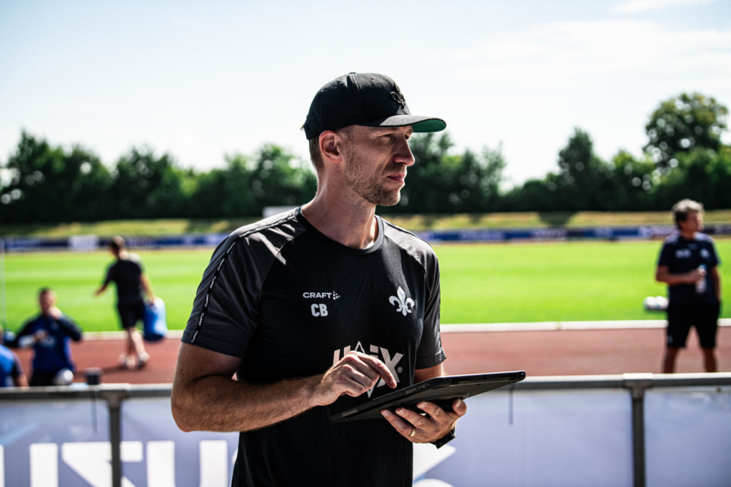 Chris Busse steht lächelnd da im Trainingslager