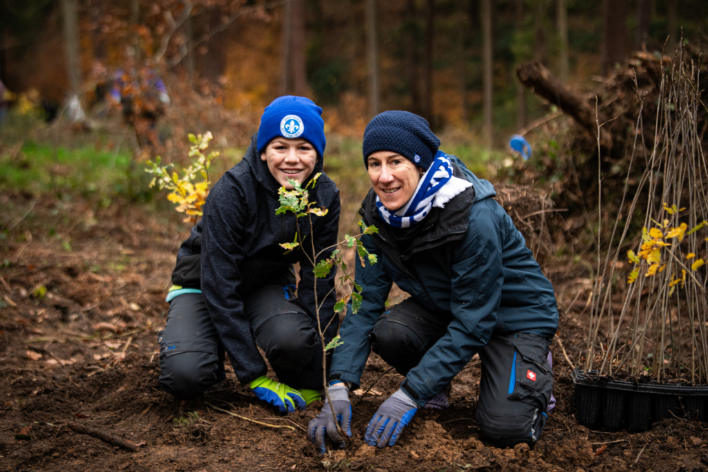 Zwei Lilien-Fans Pflanzen einen Baum bei der vergangenen Aktion