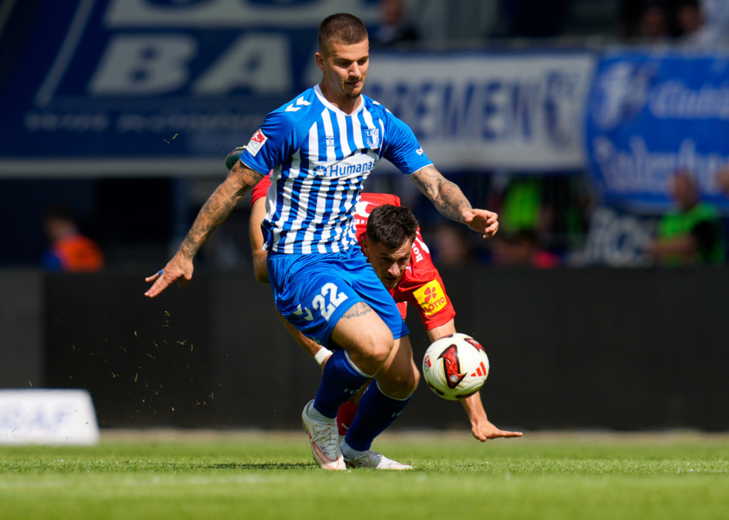 Mateusz Zukowski (1. FC Magdeburg, #22) im Zweikampf mit Adrian Kapralik (Holstein Kiel, #20)